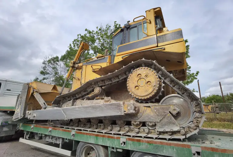The Importance of Cleanliness in Transportation -a dirty excavator on a green and brown flatbed