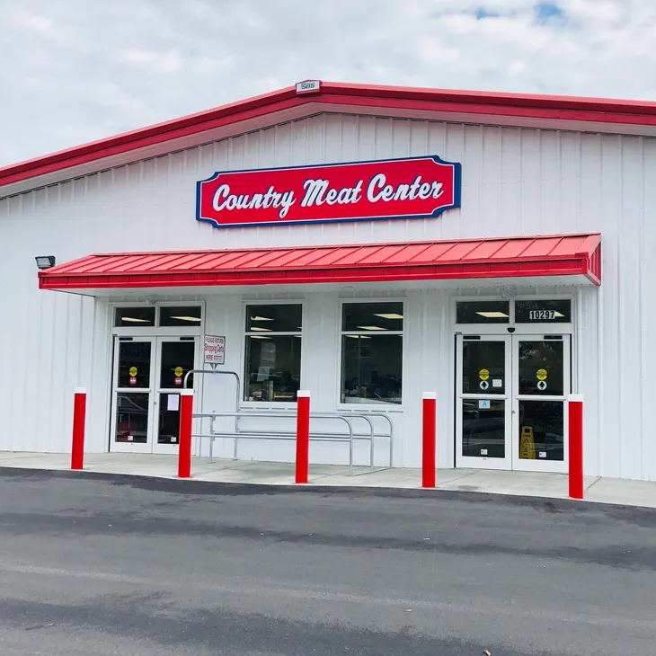 Country Meat Center- A beautiful white building with glass door entrances to a grocery store.